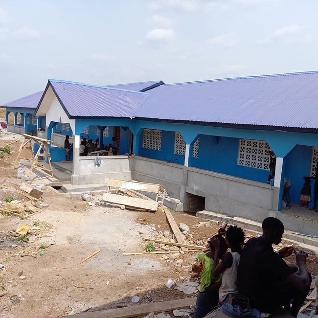The beautiful and new school, constructed in Kamabonko Village, Sierra Leone. WYCF exclusively partners with local builders to promote local economic growth and sustainability. Inside, young students excitedly await the opening.