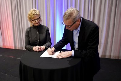 American Trucking Associations President and CEO Chris Spear signs a five-year contract extension with the association as ATA Chair Sherri Garner Brumbaugh, president and CEO of Garner Transportation Group, looks on.