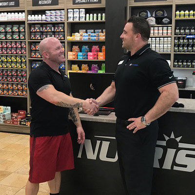 Jake Halvig (left), NUTRISHOP® franchisee of the Roseville, CA location and the flagship 24 Hour Fitness®/Nutrishop Pro Shop shakes hands with Tony Cigliutti (right), General Manager, 24 Hour Fitness Sacramento Downtown club.