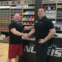 Jake Halvig (left), NUTRISHOP® franchisee of the Roseville, CA location and the flagship 24 Hour Fitness®/Nutrishop Pro Shop shakes hands with Tony Cigliutti (right), General Manager, 24 Hour Fitness Sacramento Downtown club.