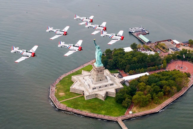 The six plane delta formation of the GEICO Skytypers Air Show Team flies over the Statue of Liberty.