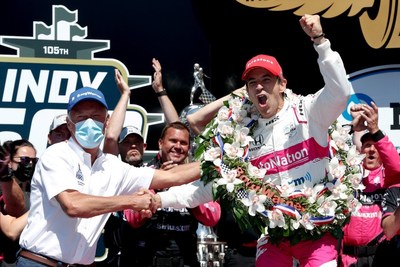 Frédéric Lissalde shakes the hand of Helio Castroneves as he celebrates his fourth Indianapolis 500 win in Victory Circle at Indianapolis Motor Speedway