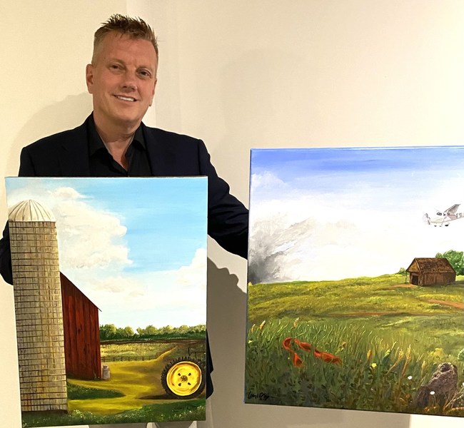 Craig Biorn with his original book cover paintings he painted for his books, Bilan's Journey of Hope and Bah Bah for Barbara
