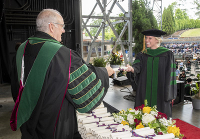 Jay S. Feldstein, DO '81, PCOM president and CEO, presents a diploma to PCOM Georgia Doctor of Osteopathic Medicine graduate Nicole Pritchett, DO '21.