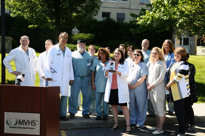 Members of the Mohawk Valley Health System (MVHS) cardiac team hold their award from the American College of Cardiology (ACC) this morning in front of St. Elizabeth Medical Center. MVHS is the first hospital in the state and one of 36 nationally to be awarded the ACC’s highest accreditation of HeartCARE™ Center: National Distinction of Excellence. Members of the team were on hand to announce the prestigious award, which is the culmination of more than two years of planning and on site testing.