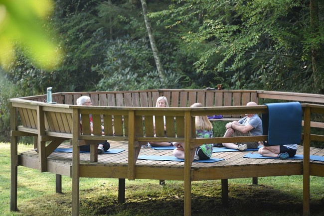 Yoga classes are given outside on the deck amongst trees by the lake. Just one of Camp Big's great activities.