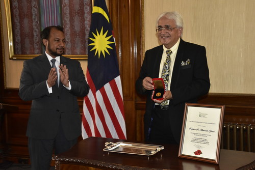 Prof. Sir Alimuddin Zumla (right) receives the 2020 Mahathir Science Award from Mr. Zahid Rastam (left), Chargé d'Affaires at the Malaysian High Commission in London.