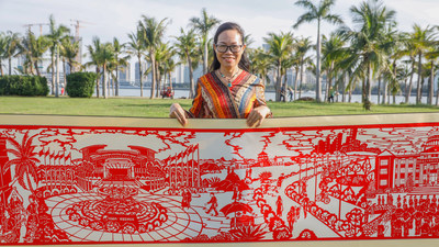 Huang Haitao, who led the papercut team, shows the part of the 22-meter scroll depicting the Boao Forum for Asia conference. (Photo/HIMC)