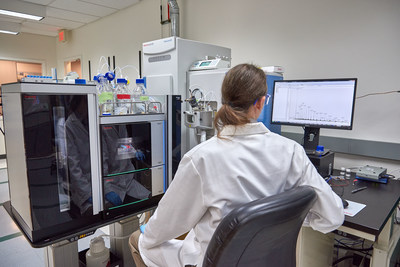 A scientist operates a Thermo Scientific Vanquish UHPLC with Q-Exactive HF-X mass spectrometer used in metabolomics research.