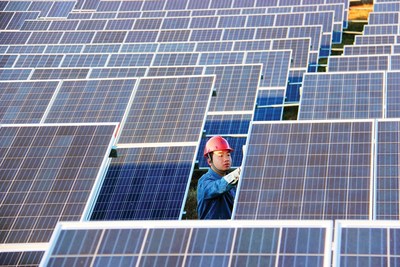 A technician of Pingqing Photovoltaic Power Station inspects solar panels in Weining in southwest China’s Guizhou province. (Photo by Huan He)