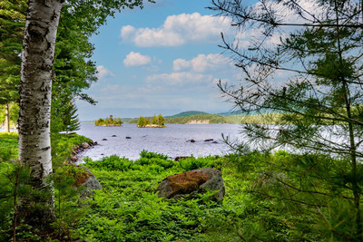 Paradise Peninsula offers many beautiful vistas of Tupper Lake, inspiring the owner to cultivate gently winding nature trails and various lookout areas throughout the grounds. Here, the property’s two ‘private islands’ can be seen just beyond the shoreline. LakefrontLuxuryAuction.com.