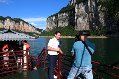 Alexander is describing the stunning natural beauty of Wu River on the cruise ship Alexander is describing the stunning natural beauty of Wu River on the cruise ship
