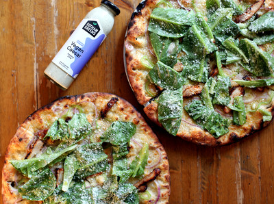Pizza Loves Emily’s Gotham City Caesar: A white wood-fired pizza topped with roasted chicken, havarti, peppers, onions, pecorino and Gotham Greens Romaine lettuce, then finished with Gotham Greens Vegan Caesar dressing.