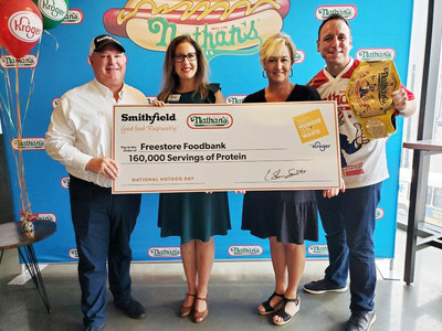 (From left to right) Vice President of National Accounts at Smithfield Foods Tim Totin, Corporate Affairs Manager for Kroger Cincinnati-Dayton Division Erin Rolfes, Chief Development Officer & VP of External Affairs at Freestore Foodbank Trisha Rayner, and Competitive Eater Joey Chestnut gather in Cincinnati on National Hot Dog Day for a donation of 160,000 servings of protein to Freestore Foodbank.