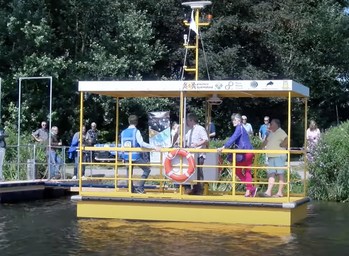 Autonomous robotaxi solar electric commercial ferry service boat leaving dock with Dutch passengers.