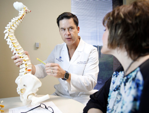 Dr. Lee Moroz at Texas Spine & Scoliosis in Austin consults with a back pain patient.