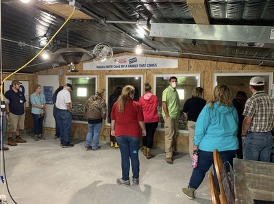 Students and leaders in the agricultural community view chickens undisturbed in their environment through windows in the new Poultry Education Center, built by Perdue farmer Steven Brake.