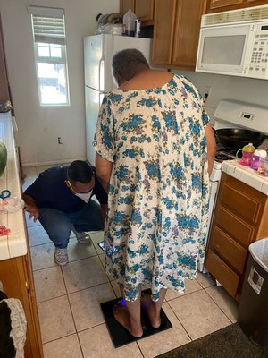 IEHP Health Navigator, Mauricio, helps pilot program participant set her digital weight scale up in her residence. The scale is just one tool the program provides to help Members make informed decisions about their health.