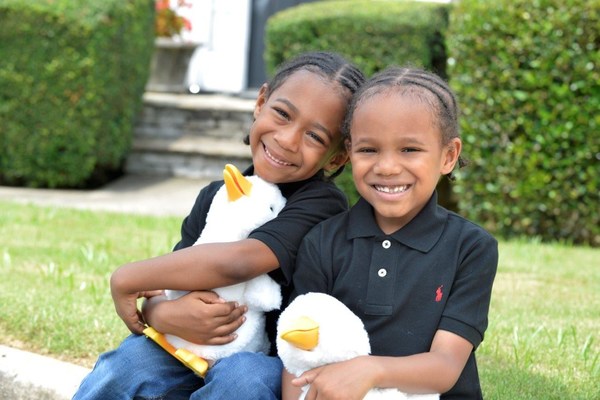 Saxton (l) with twin brother Sawyer (r), a sickle cell disease patient at the Aflac Cancer and Blood Disorders Center in Atlanta, hold My Special Aflac Duck, which Aflac will begin distributing to children with sickle cell disease in early 2022.