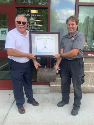 Paul Hanson, left, P.E., regional engineer for the Ductile Iron Pipe Research Association, presents Eric Carty, water and sewer superintendent for the Hopkinton, MA, Department of Public Works, with a plaque welcoming Hopkinton into the associations Century Club due to a cast-iron pipe in its water system laid in 1877 that remains in use today.