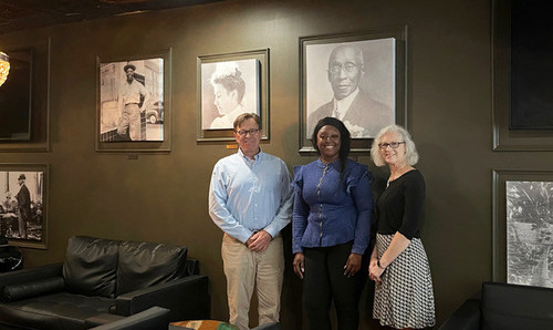 Dr. Alan Bliss, CEO and Kate Hallock, Marketing, of the Jacksonville Historical Society with The Pillars Club project manager Consuelo Lennox standing in front of the curated historical art.