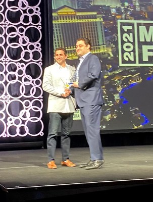 Eric Simon, Vice President Sales & Development at The Joint Chiropractic, accepts the 2021 Top$core Award from FRANdata at the Multi-Unit Franchising Conference.