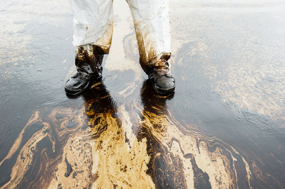 Clean up worker stands in the Orange County oil spill