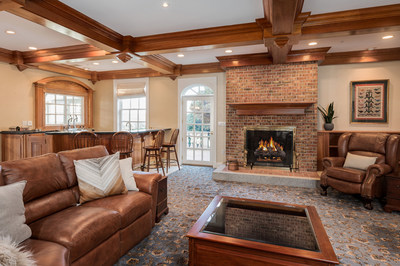 This cozy living area provides direct access to the indoor pool. A wood-burning fireplace offers charm, while a wet bar with an old-fashioned soda fountain dispenser adds a touch of whimsy.  NewHampshireLuxuryAuction.com.