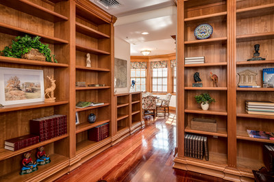 Handsome woods are used throughout the interiors, as shown here in the executive study/library. Natural light pours in from the semi-circular windows surrounding the meeting area. NewHampshireLuxuryAuction.com.