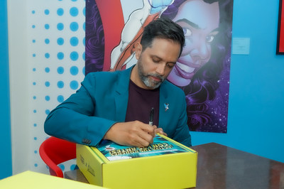 Chocolate Cortés joins forces with La Borinqueña creator, Edgardo Miranda-Rodriguez seen signing box with limited edition hot chocolate bars featuring new La Borinqueña comic strips benefitting Fundación Cortés via the new Activate Your Powers With the Arts program