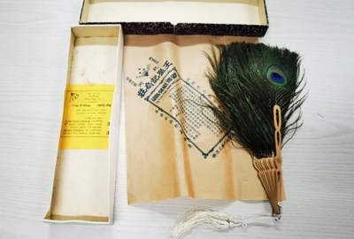 A folding fan made of peacock feathers with original case and wrap, a commodity sold at the Wangxingji Fan Store, a time-honored local trademark of Hangzhou during the Republic of China (1912-49). From the collection of the Hangzhou Museum[Photo/Official WeChat account of Hangzhou Museum]