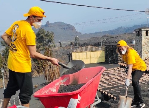 Scientology Volunteer Ministers shovel ash off the roofs of houses in La Palma after the volcanic eruption