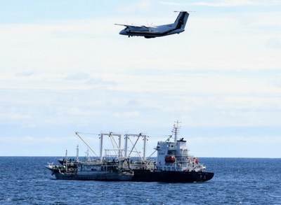 Aronef de patrouille canadien survolant un navire de pche et un navire transporteur en haute mer dans l'ocan Pacifique Nord. (Groupe CNW/Pches et Ocans Canada)