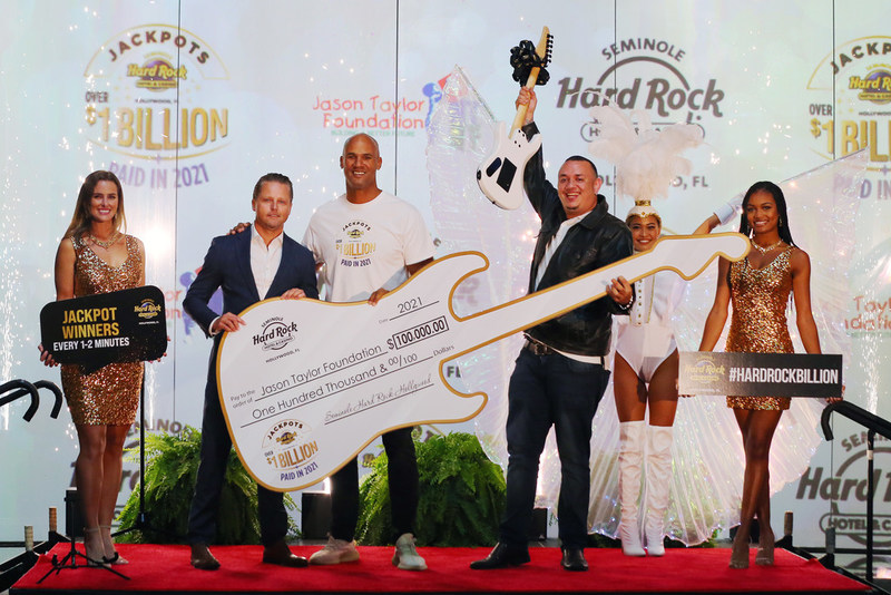 Justin Wyborn, assistant general manager of Seminole Hard Rock Hotel & Casino Hollywood, Jason Taylor, and Sergio Montoya pose with a large check