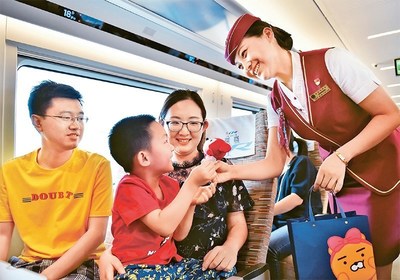 An attendant interacts with passengers on a high-speed train. A whole raft of services including electronic tickets, online meal ordering, quiet carriages, and smart interfaces have been launched on China's high-speed rail network, providing passengers with a safe, comfortable, and convenient travel experience.