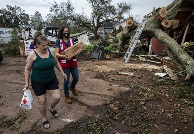 In 2021, extreme disasters devastated communities already coping with the ongoing challenges of the COVID-19 pandemic. Here, in response to Hurricane Ida, American Red Cross volunteer Andrea Godshall delivered relief supplies to Denise Bergeron at her hard-hit home in Luling, Louisiana. Photo by Scott Dalton/American Red Cross