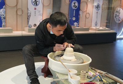 An artist shows trimming, one of porcelain making skills, in Gao'an Yuan Dynasty blue and white porcelain Museum, Nov. 20, 2021.