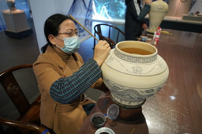 An artist shows painting, one of porcelain making skills, in Gao'an Yuan Dynasty blue and white porcelain Museum, Nov. 20, 2021.