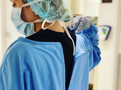 Kennia Melendez, healthcare hero at The Texas Medical Center, shows the unique snap of Accel Unite's Reusable Isolation Gown. The unique snap provides safer doffing, as her contaminated sleeves will not be near her face. These proprietary gowns protect against cross contamination.