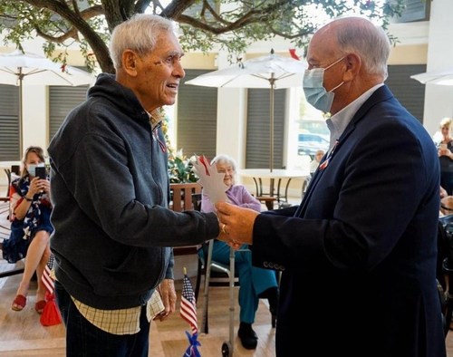 At Market Street Memory Care Residence East Lake, Florida Senator Ed Hooper honors a resident veteran for his service.