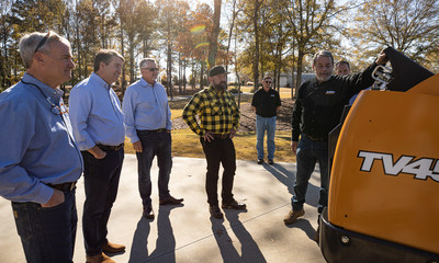 Representatives of CASE Construction Equipment deliver a new machine to Zac Brown at Camp Southern Ground