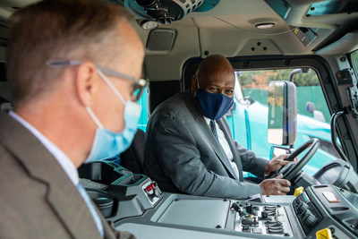 UAW president Ray Curry speaks with Mack Trucks employee Scott Barraclough as he test drives the Mack LR Electric emission-free Class 8 refuse truck.