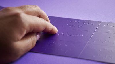A hand reading a purple braille legend. (CNW Group/Purdys Chocolatier)