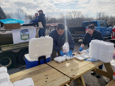 Edgardo Ortiz Torres, center, director of Perdue operations in Cromwell, Ky., and associate Autumn Schulz prepare meals for first responders, volunteers, and storm victims at the Ohio County Fairgrounds in Hartford, Ky., on Tuesday, Dec. 14.