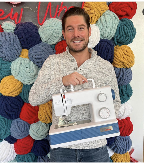 Craig Conover holding a bernette 05 Academy Sewing Machine at Sewing Down South's Flagship Store in Charleston, South Carolina