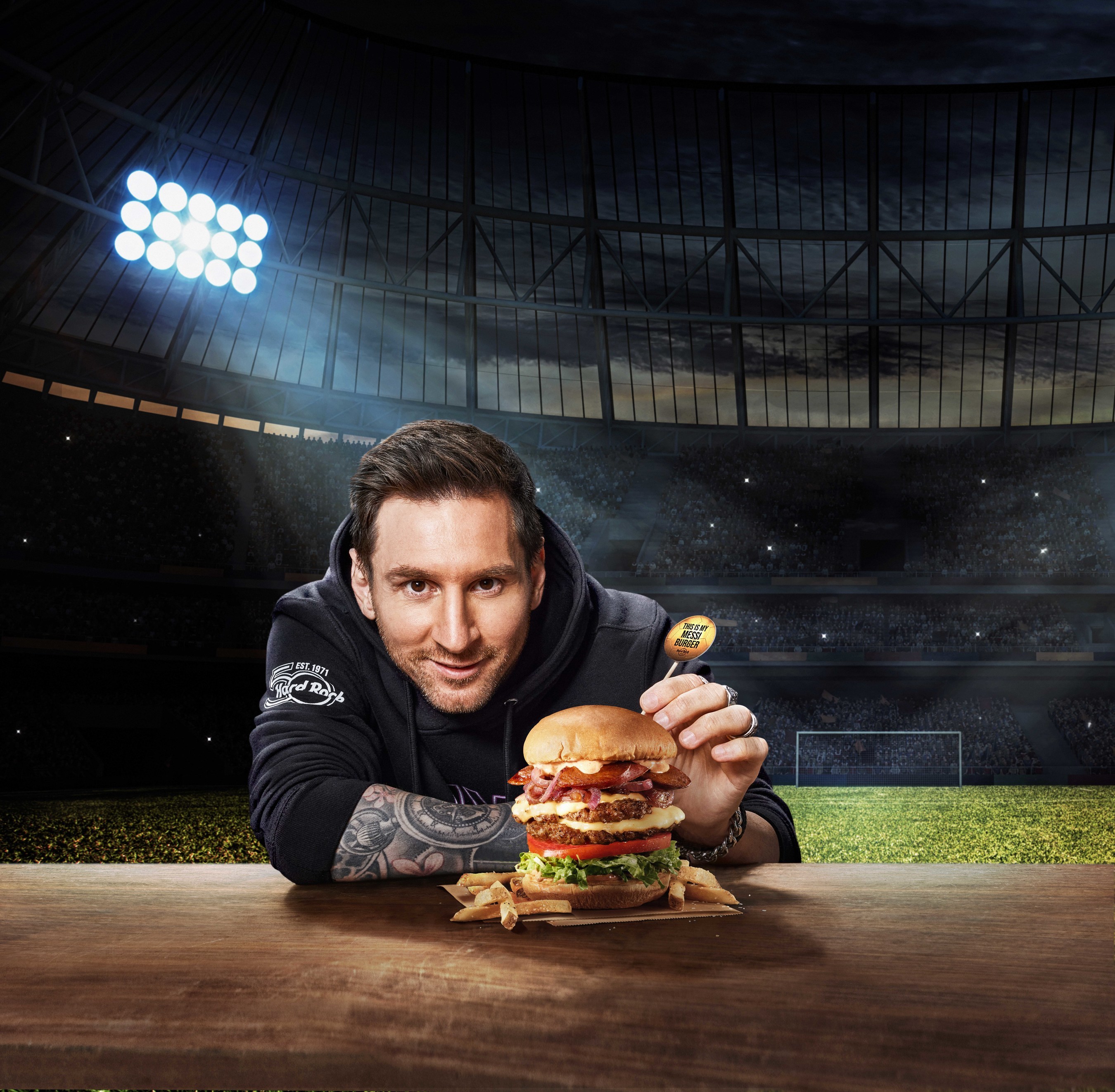 Messi posando com Messi Burger do Hard Rock