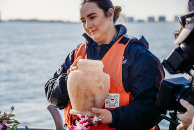 Animal Care Specialist holds Winter's ashes before releasing her into the Gulf of Mexico.