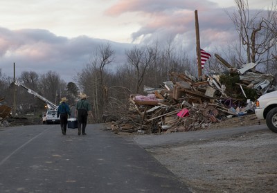 An Amish father and son off food and drinks as they walk through a tornado destroyed subdivision in Kentucky.
