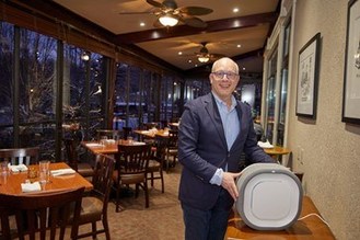 Yehuda Ordower, Managing Partner at Aura Canada helps install an Aura Air purifier in the Miller Tavern, the first restaurant in Canada to use new technology clinically proven to kill the Coronavirus. (CNW Group/Aura Air)