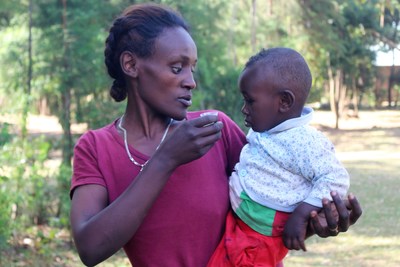 A woman helps her child take a dose of trachoma-fighting antibiotics in Ethiopia. Photo: Orbis International